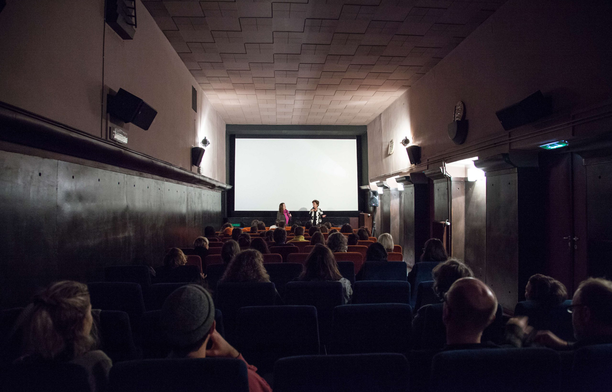 Ein kleiner Kinosaal mit Blick auf die Leinwand. Zwei Personen – Wilbirg Brainin-Donnenberg und Ruth Beckermann – im Gespräch vor der Leinwand.